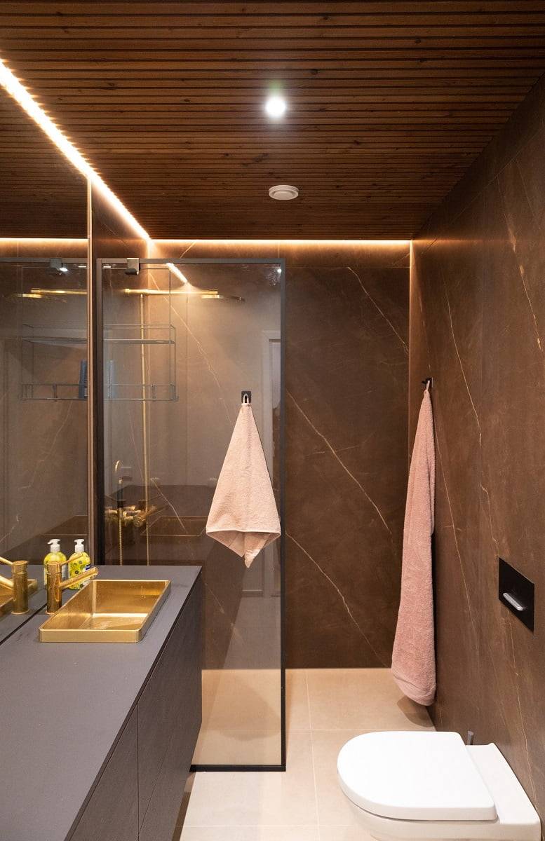 En el cuarto de baño, la luz llega a toda la longitud del espejo con una tira LED indirecta en un perfil esquinero. Los puntos se sitúan a lo largo de la línea central. © LedStore.fi
