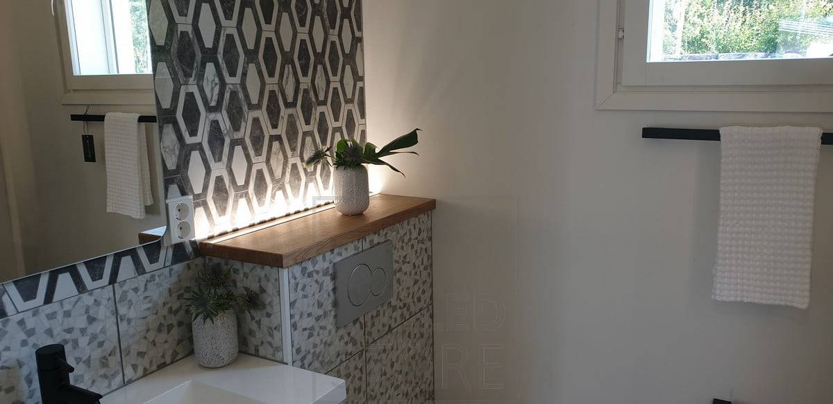 Tira de LED detrás de la carcasa del inodoro, orientada hacia arriba, que crea una bonita luz de ambiente, también funciona como luz nocturna. Ledstore.fi