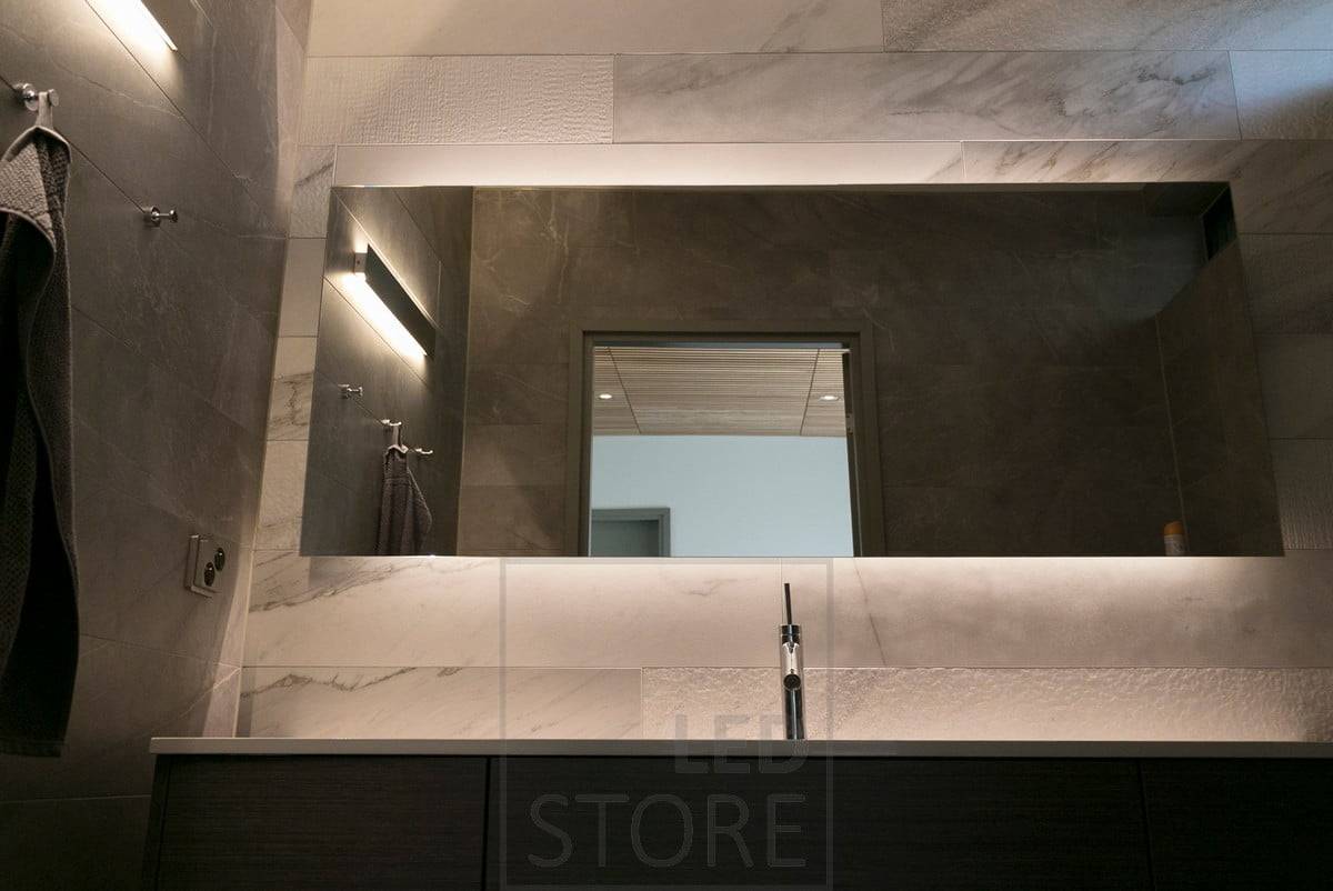 Detrás de un hermoso espejo de gran tamaño, una tira de LED resalta el espejo y crea una iluminación ambiental. Además, un aplique bidireccional. Ledstore.fi