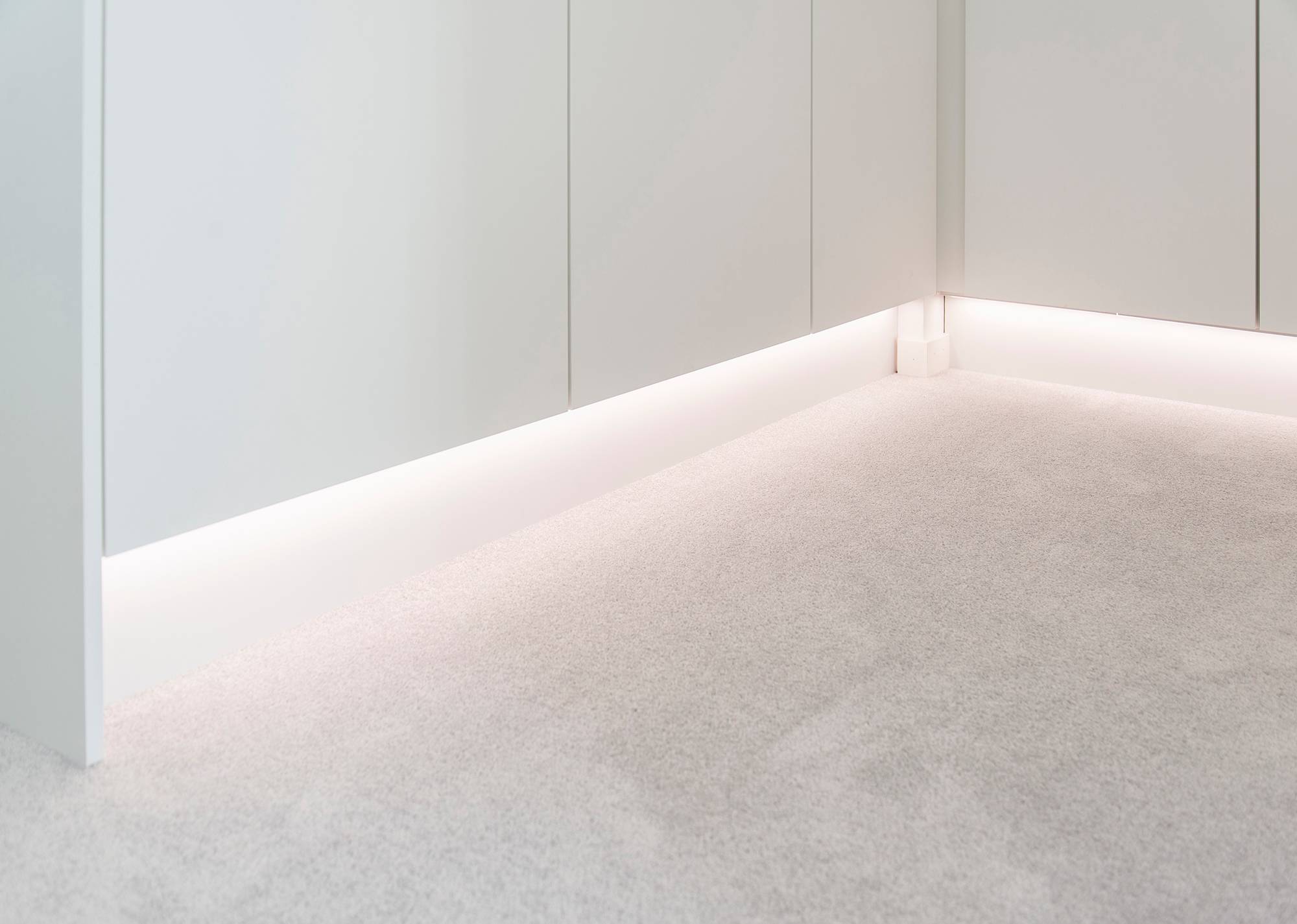 Una tira de luz LED en la base de un armario, que proporciona una luz indirecta y atmosférica. Temperatura de color de la luz 4000K Ledstore.fi