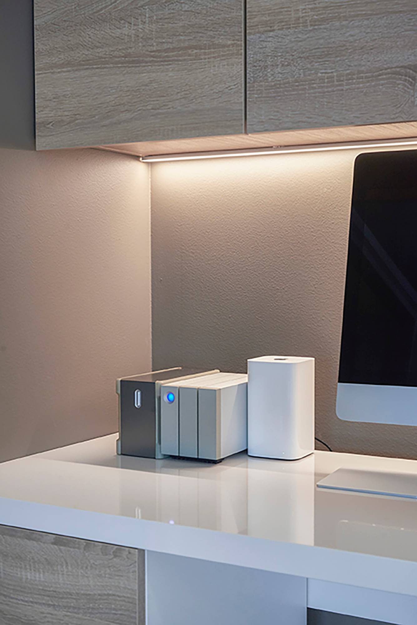 Pared iluminada indirectamente detrás de un puesto de trabajo con una tira de leds. La luz es atmosférica y agradable a la vista. Ledstore.fi