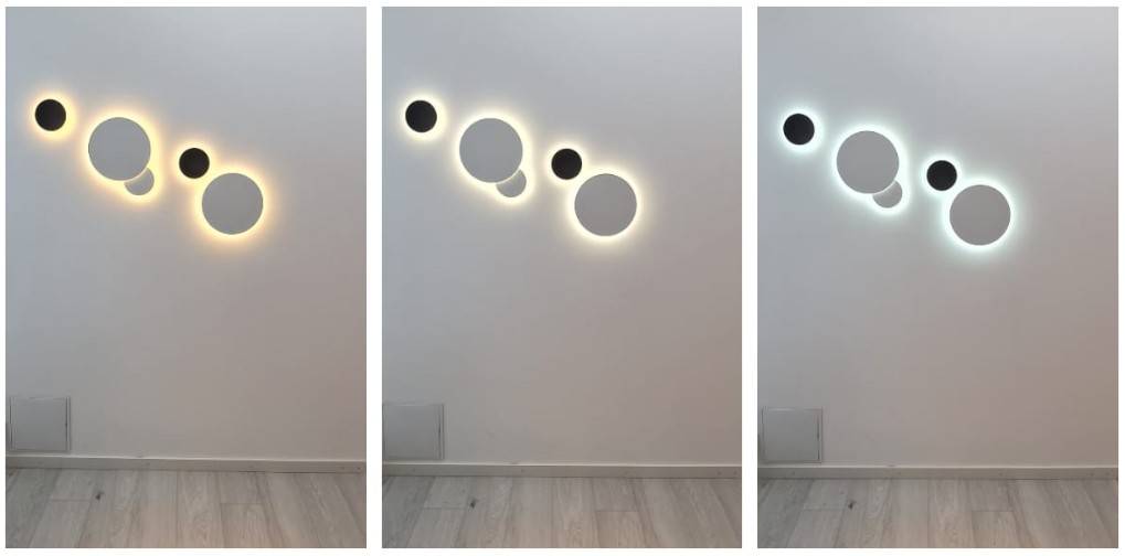 Luminarias murales redondas Eclipse agrupadas en una serie de cinco luminarias.