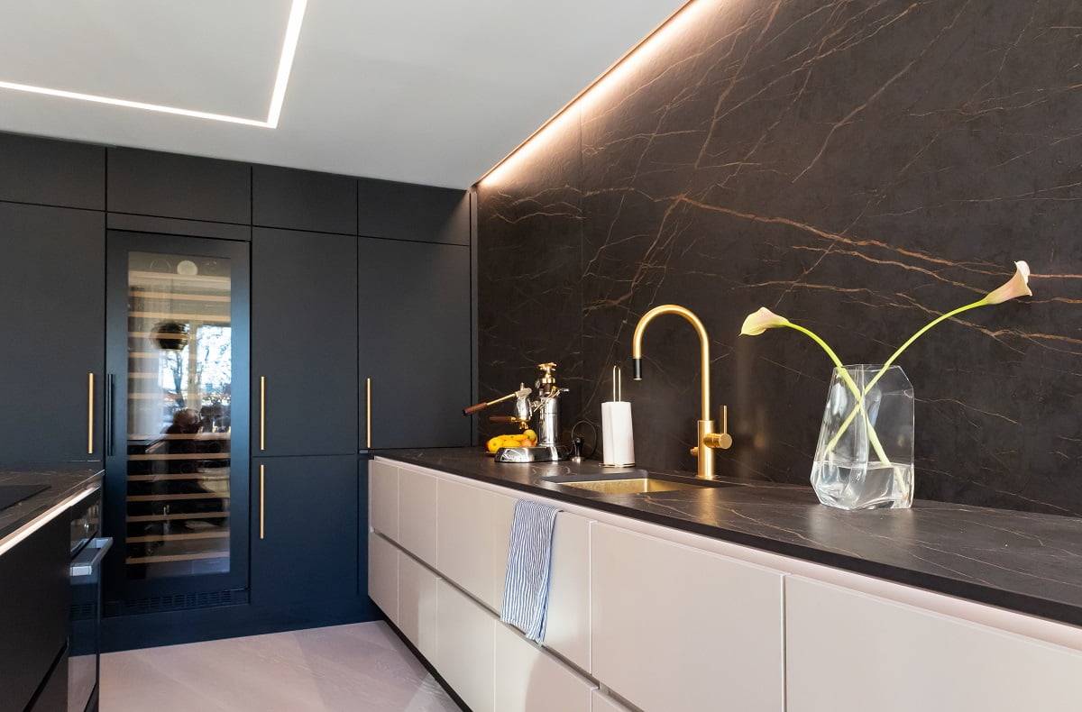 En la zona de trabajo de la cocina, hay un foco plano en el techo y una tira de luz LED hacia la pared como luz de acento. © LedStore 