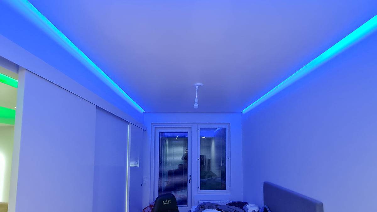 Luz indirecta en el techo. un momento azul en el techo bajo de un dormitorio