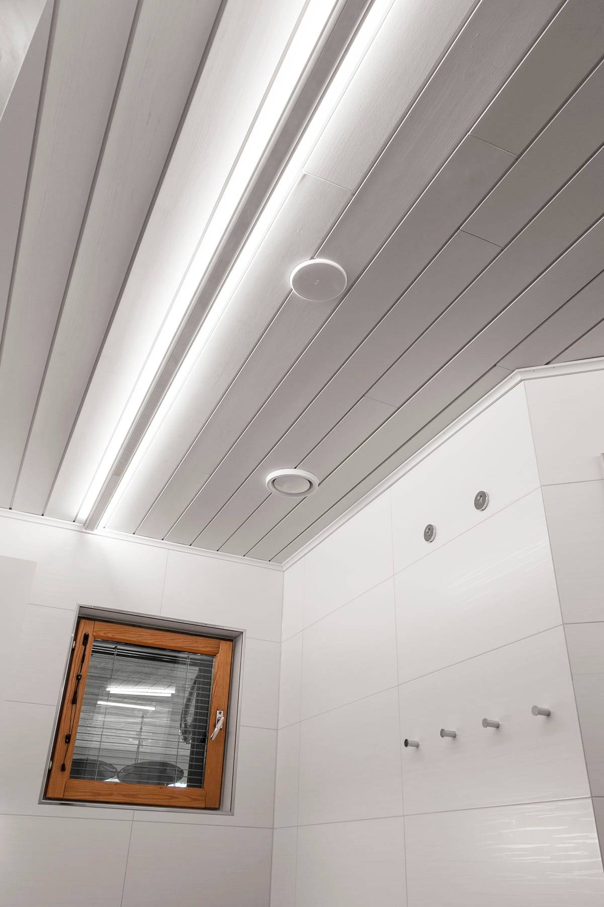 perfiles led en el techo que dan luz indirecta al cuarto de baño