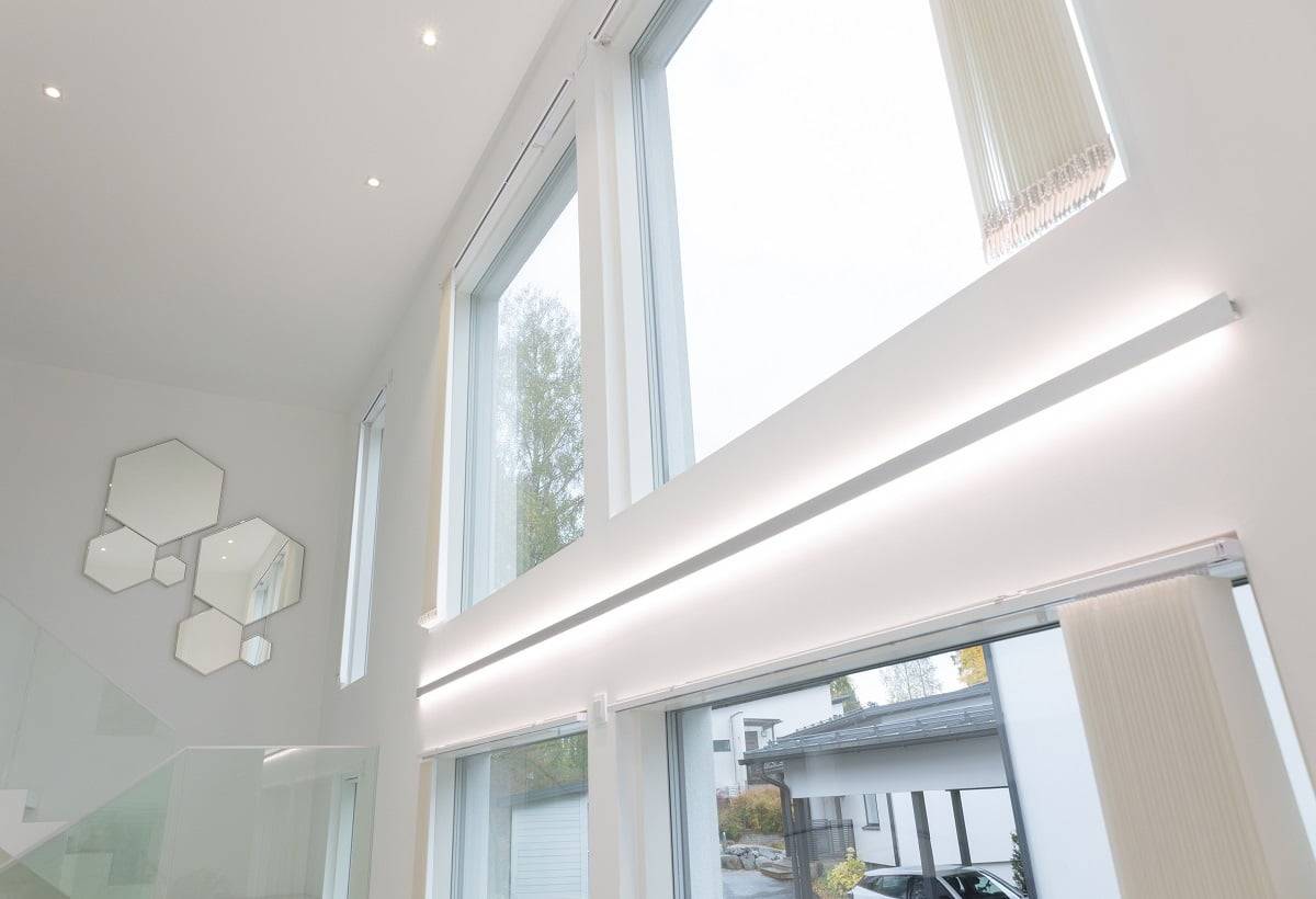Iluminación interior LedStore - un ambiente moldeado por la luz LedStore.fi tienda online descripción del producto: el moderno interior presenta impresionantes ventanas grandes y altas, problemas con la elegante iluminación LED. Esta iluminación permite la entrada de luz natural. En las paredes blancas hay un conjunto de espejos hexagonales artísticamente dispuestos cerca de la escalera con una balaustrada de cristal. En el exterior, el camino de entrada está bordeado de coches aparcados, lo que completa el estilo moderno.