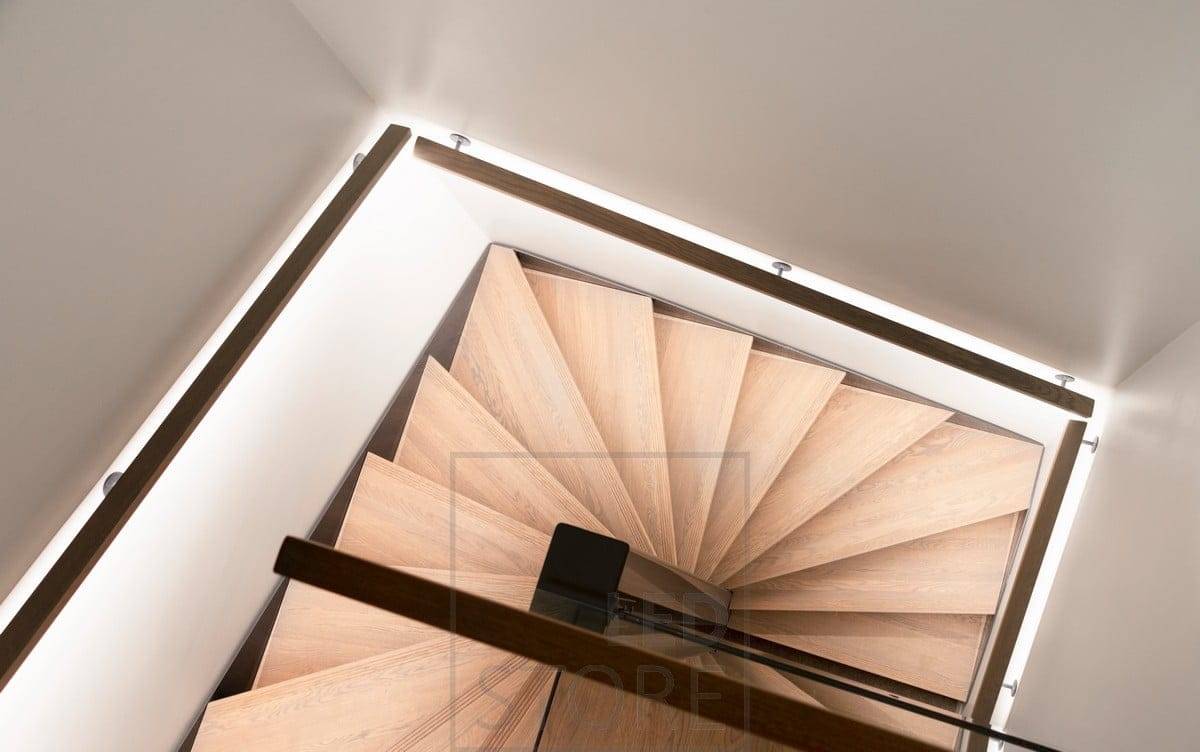 El pasamanos de la escalera tiene una tira de LED que apunta hacia abajo, iluminando los peldaños. Ledstore.fi 
