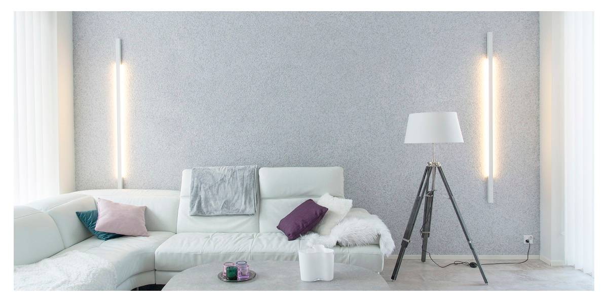 el diseño de la iluminación de un salón es importante, en la imagen un salón armonioso con apliques en la pared del fondo