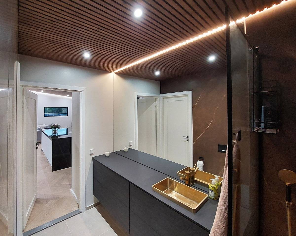 El cuarto de baño tiene una iluminación adecuada con una combinación de focos de 9 W y tiras de luces LED