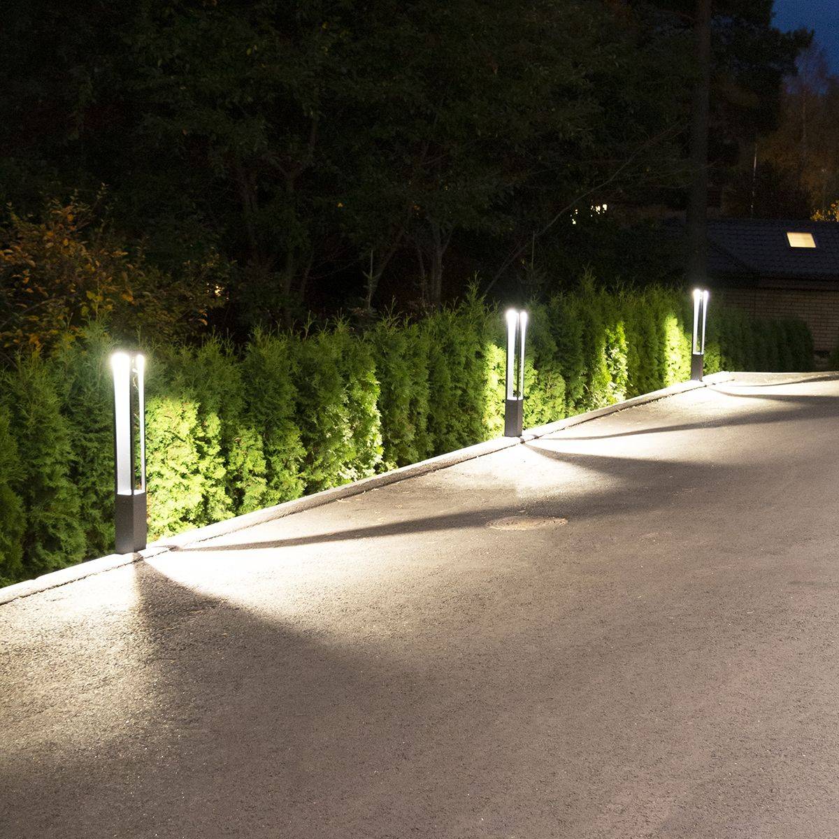 Las luces de los pilares situados en el borde de la parcela iluminan el patio.