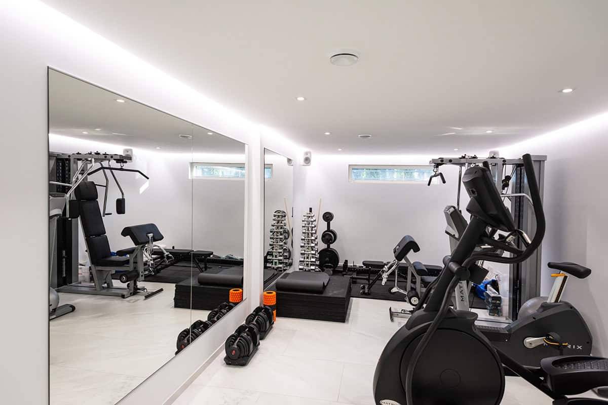Un pequeño gimnasio con tiras de iluminación LED y focos.