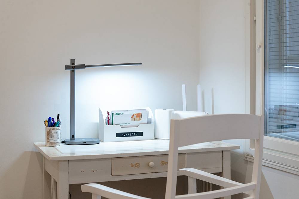 La lámpara de mesa Crane de LedStore ilumina un puesto de trabajo ligero.