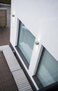 La iluminación exterior puede conseguirse con los populares apliques de pared, que toman reflejos adicionales de la superficie blanca.