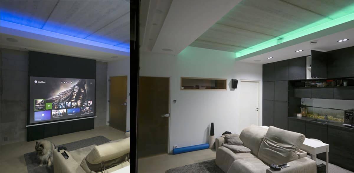 Moderno salón con iluminación LED LedStore.fi para cine en casa, pantalla de proyector, cómodos asientos y un perro en el suelo.